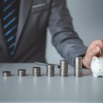 Person with pile of coins and piggy bank, money saving concept for future use and financial stability, salary management, personal finance, investment savings.